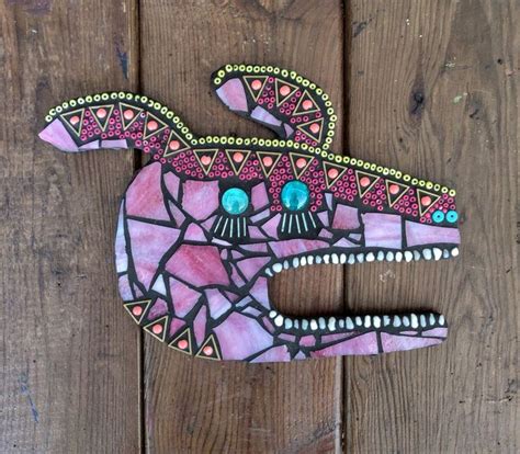 A Pink And Black Cat Made Out Of Mosaic Tiles On Wooden Planks With