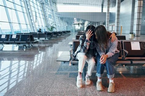 Sad young girl crying with her friend when sitting in the modern airport 15171620 Stock Photo at ...