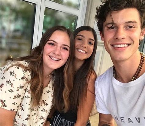 Two Girls And A Boy Are Smiling For The Camera