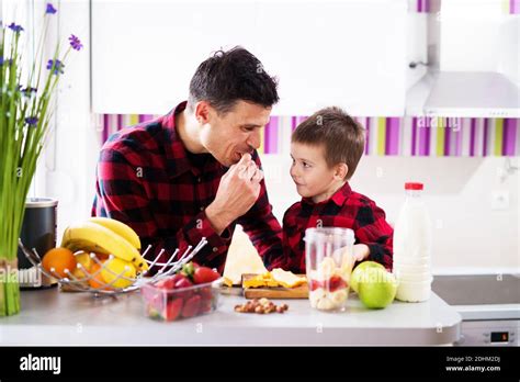 El joven y alegre padre y su hijo están desayunando juntos en el