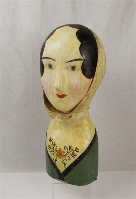 A Wooden Statue Of A Woman S Head With Black Hair And Flowers On It