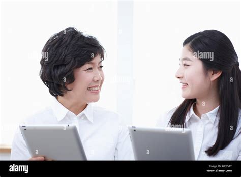 Portrait Of Smiling Mother And Smiling Middle School Girl With Tablets