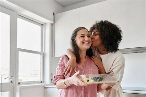 Woman Kissing Her Friend After A Dinner Party By Stocksy Contributor