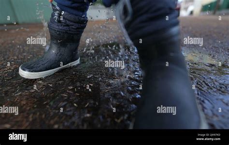 Little Child Jumping Into Puddle Wearing Boots Stock Photo Alamy