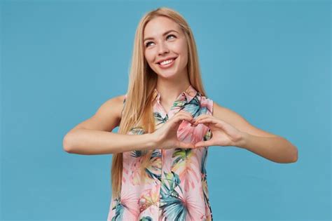 Belle Dame Blonde Positive Aux Cheveux Longs En Robe Romantique Coeur Pliant Avec Les Mains