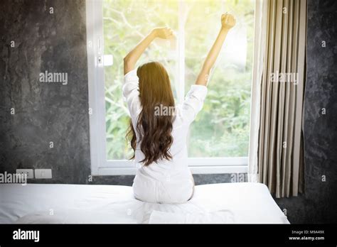 Asian Woman Beautiful Young Smiling Woman Sitting On Bed And Stretching