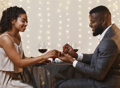 Young Black Couple Getting Engaged In Restaurant Stock Photo Image Of