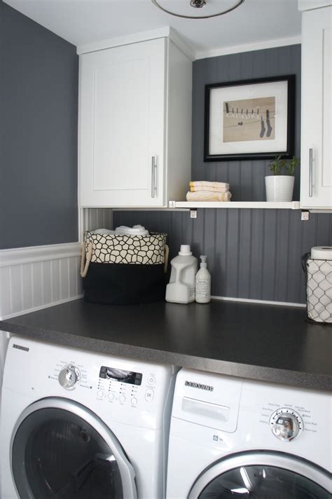 A Washer And Dryer In A Small Room With White Cabinets Black Counter