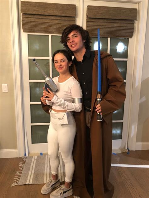 A Man And Woman Dressed Up As Star Wars Characters Standing In Front Of