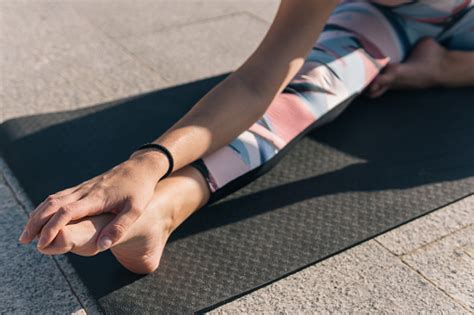 Cropped Shot Of A Woman Doing Leg Stretches Grabbing Her Foot With Her