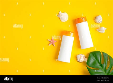 Two White Plastic Sunscreen Lotion Bottles Seashells And Tropical Leaf