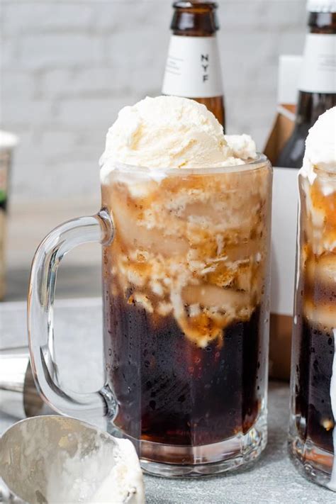 Two Mugs Filled With Ice Cream And Caramel On Top Of A Table Next To