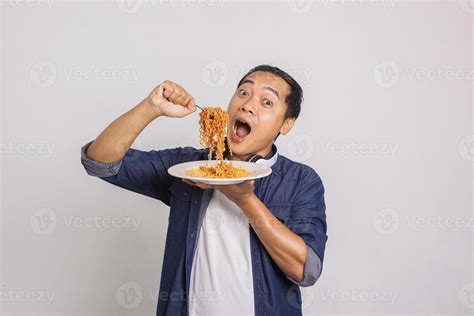 Asian Man Eating Instant Noodle And Feel Surprise With How Delicious It