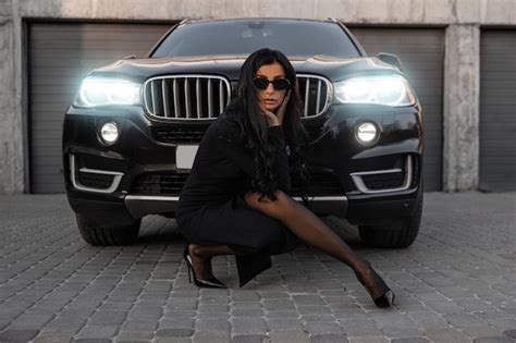 Premium Photo | A girl near the car in a black dress