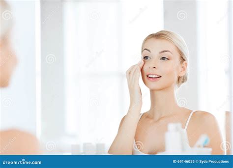 Happy Woman Applying Cream To Face At Bathroom Stock Image Image Of Cream Cheerful 69146055