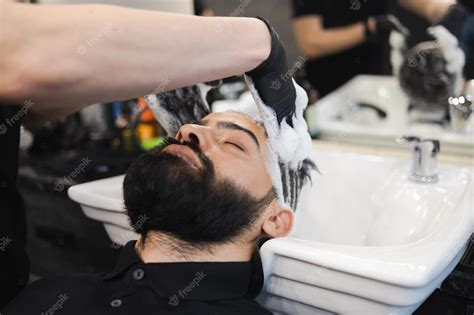 Premium Photo Man Relaxes While Washing His Hair In A Barbershop