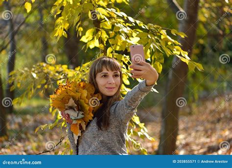 Beautiful Girl Takes Pictures On The Phone In The Autumn Park Selfie