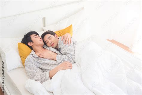 Young Asian Gay Couple Wearing Pajamas Sleeping On The Bed Together At Homehomosexual Couple