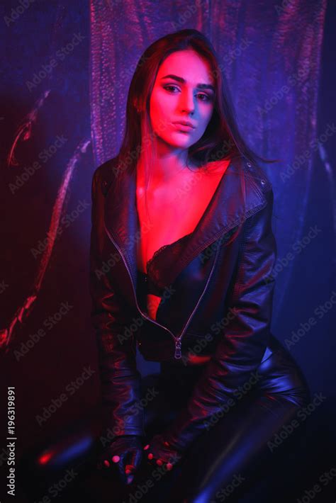 Portrait Of Sexy Girl With Long Hair In Leather Jacket Seated