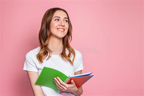 Student Girl Smiles And Stands Isolated Over Pink Background And Look