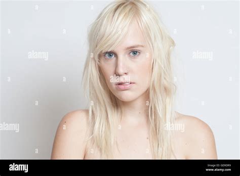 Très belle jeune femme blonde aux yeux bleus abattu en blanc avec épaules nues Photo Stock Alamy