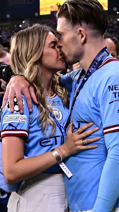 a man and woman kissing in front of a crowd at a sporting event with ...