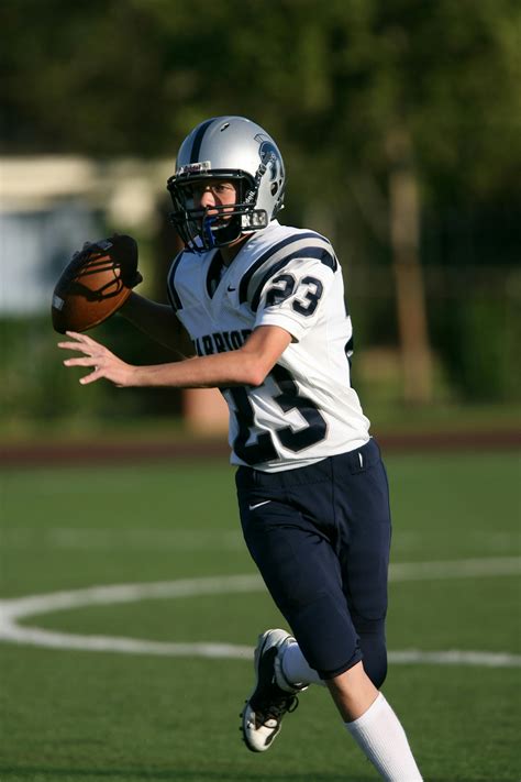 Man Wearing Green American Football Jersey Holding the Ball While ...