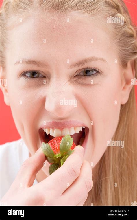 Woman Biting Into A Strawberry Stock Photo Alamy