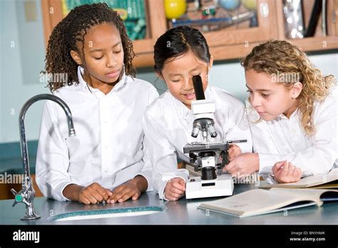 Multi Ethnic Elementary School Children In Science Lab Using Stock