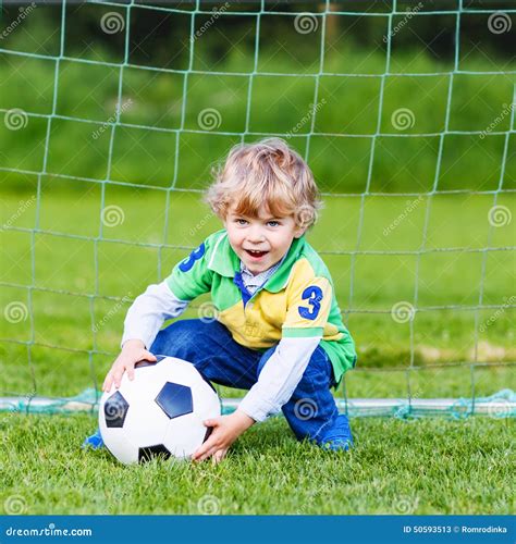 Adorable Cute Little Kid Boy Playing Soccer And Football On Field Stock