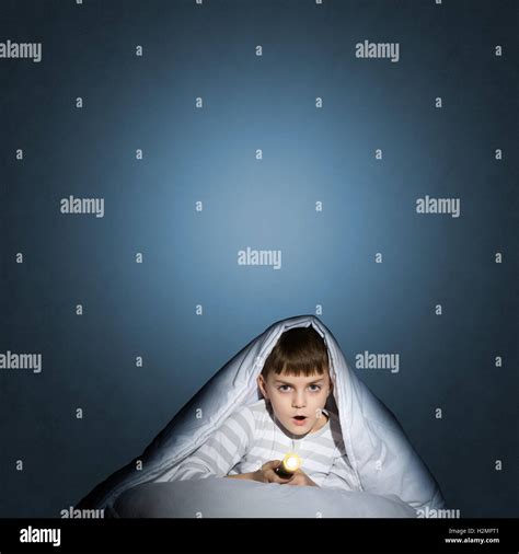 Boy Under The Covers With A Flashlight Stock Photo Alamy