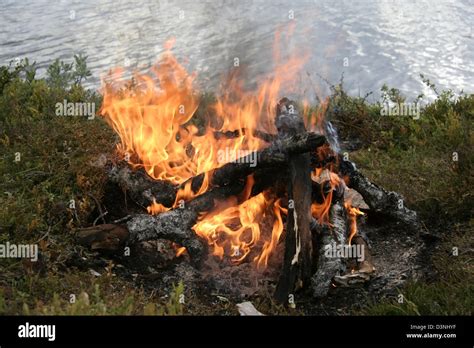 Camp fire by the lake Stock Photo - Alamy