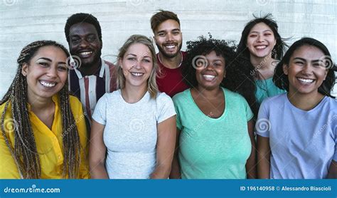 Group Of Multiracial Friends Sitting On A Tble Outdoor Using