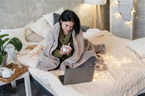 Foto Completa De Mulher Sentada Na Cama Um Laptop Foto Premium