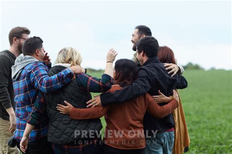 A United Group Of People Standing With Arms Around Each Other Stock