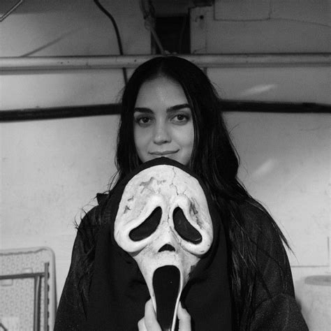 A Woman Holding A Fake Skull In Front Of Her Face