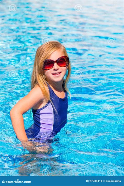 Fille Blonde D Enfant Dans Le Regroupement Bleu Posant Avec Des