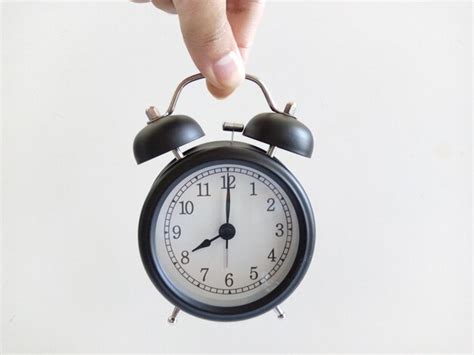 Premium Photo Cropped Hand Of Person Holding Alarm Clock Against