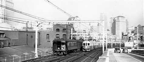 A Large Interurban Electric Railway Red Train Approaches The Bay Bridge