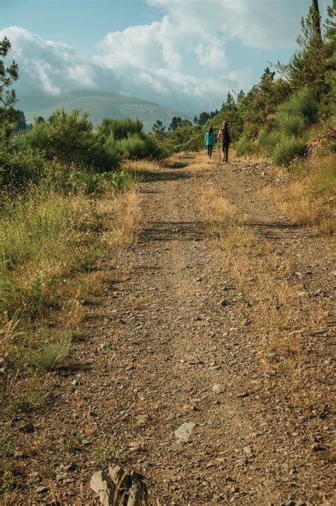 Povos Que Caminham Na Estrada De Terra Sobre O Terreno Montanhoso