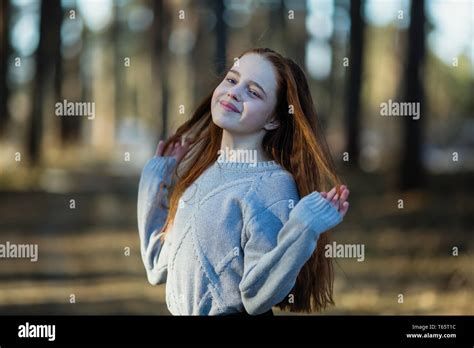 Twelve Year Old Cute Girl With Long Red Hair Posing For The Camera In