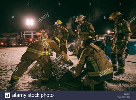 Firefighters tending to victim at scene of car accident Stock Photo - Alamy