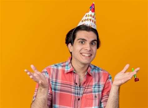 Impresionado apuesto hombre caucásico vistiendo gorro de cumpleaños