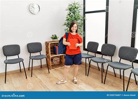 Brunette Woman With Down Syndrome Standing Wearing Bag At Waiting Room