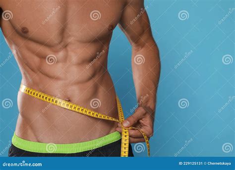 Shirtless Man With Slim Body And Measuring Tape Around His Waist On