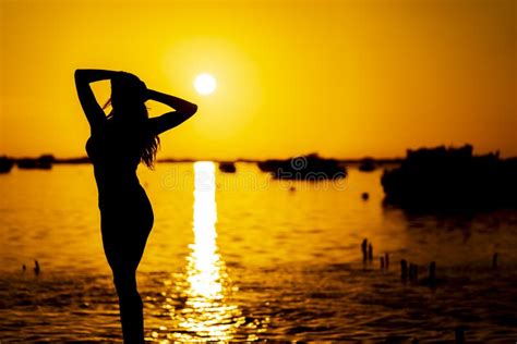 A Lovely Nude Latin Model Is Silhouetted As She Poses With The Rising Sun Behind Her On A