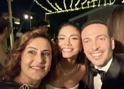 Two Women And A Man Posing For The Camera At A Formal Event With Lights