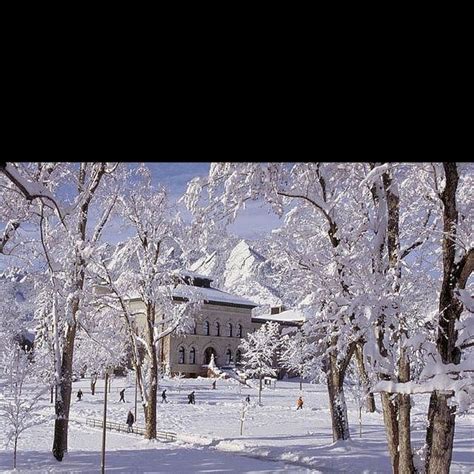 People Are Walking Through The Snow In Front Of A Large Building With