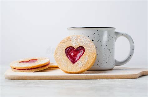 Biscuits Remplis De Confiture En Forme De Coeur Et Linzer De Tasse