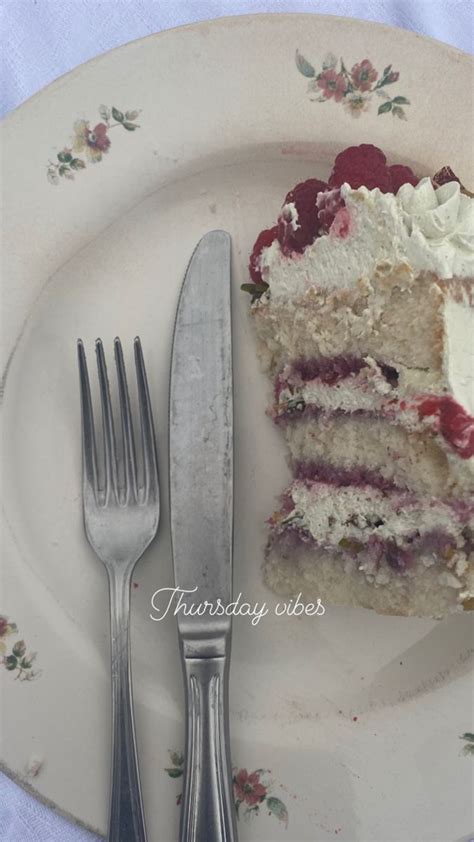 A Piece Of Cake With White Frosting And Berries On It Next To A Fork